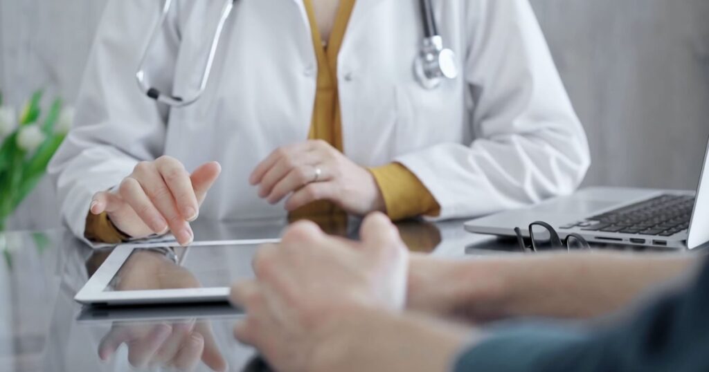 Un médecin en consultation, utilisant une tablette.