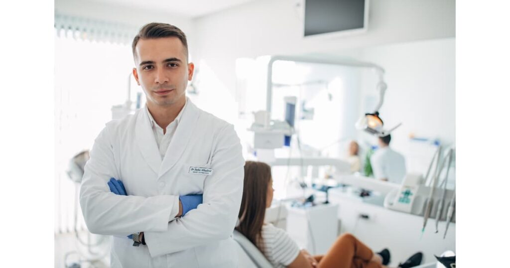 Cabinet de dentiste avec dentiste qui croise les bras.