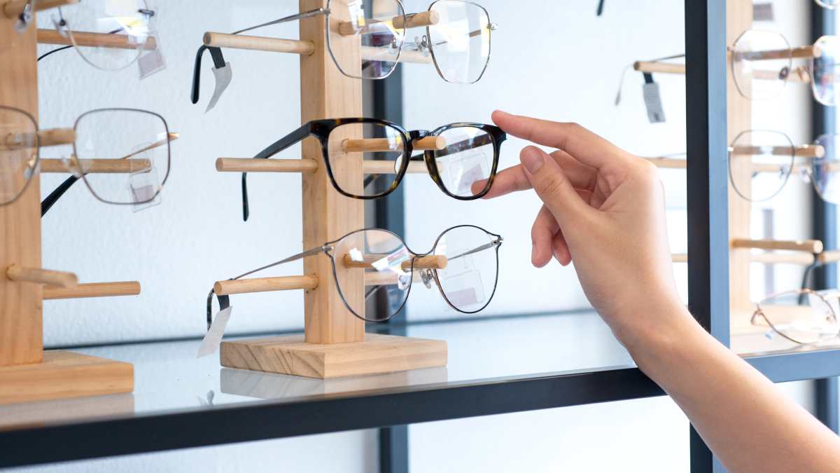 Une cliente qui choisit une paire de lunettes chez un opticien.