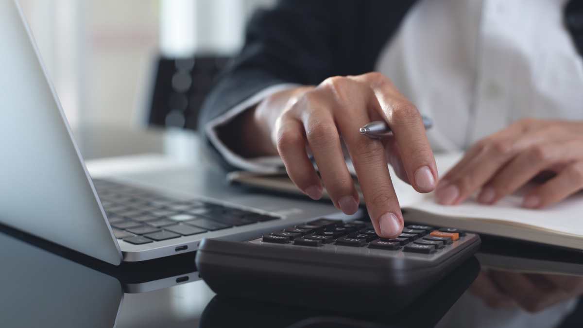 Un homme calcule ses remboursements avec une calculatrice.