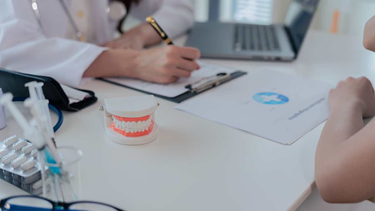 Une dentiste qui prend note après une consultation avec un patient.