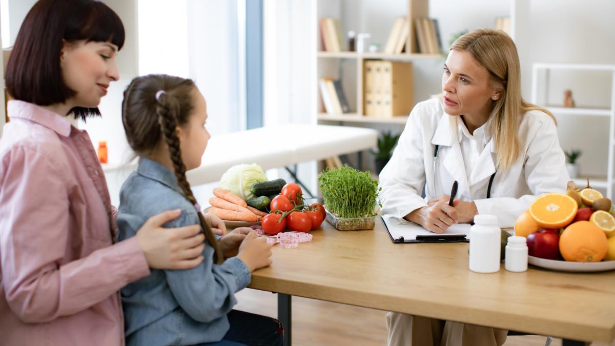 Consultation chez une diététicienne avec une mère et sa fille.