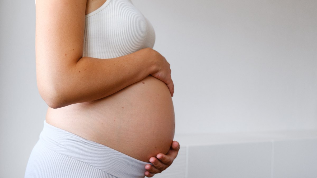 Femme en enceinte tenant son ventre.