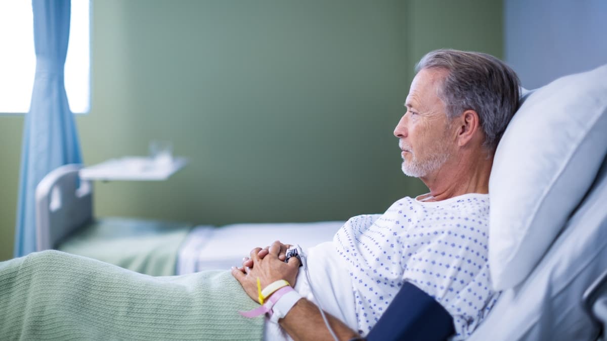 Homme âgé allongé sur un lit d'hôpital.