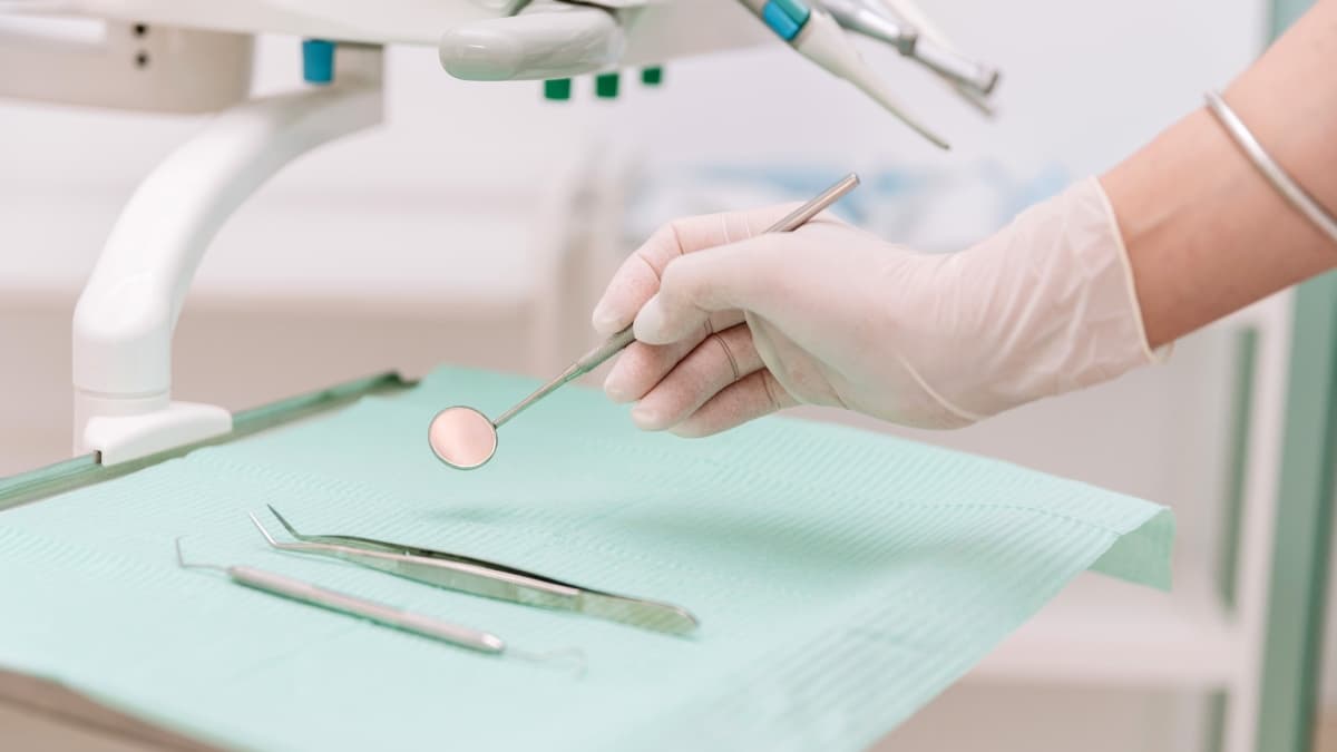 Dentiste utilisant ses instruments de travail lors d'une consultation.