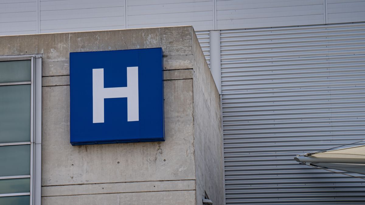 Devanture d'un hôpital avec logo bleu et police d'écriture blanche.
