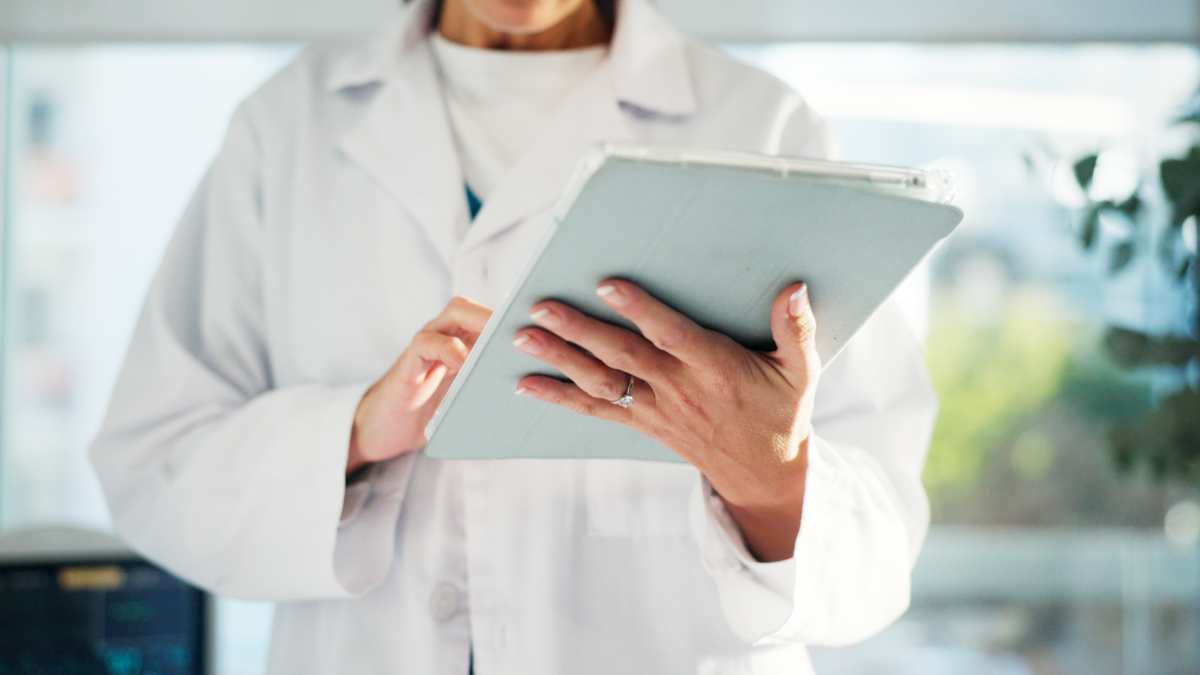 Un médecin qui tient un carnet dans ses mains.