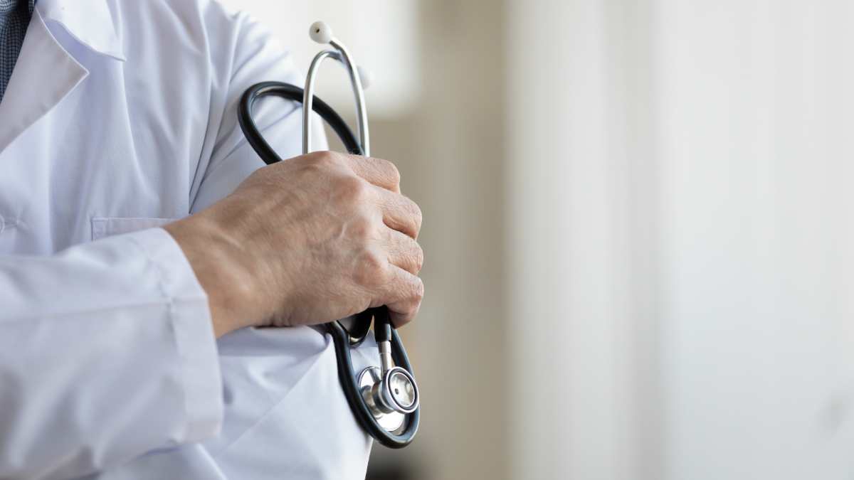 Un médecin généraliste qui tient un stéthoscope dans les mains.