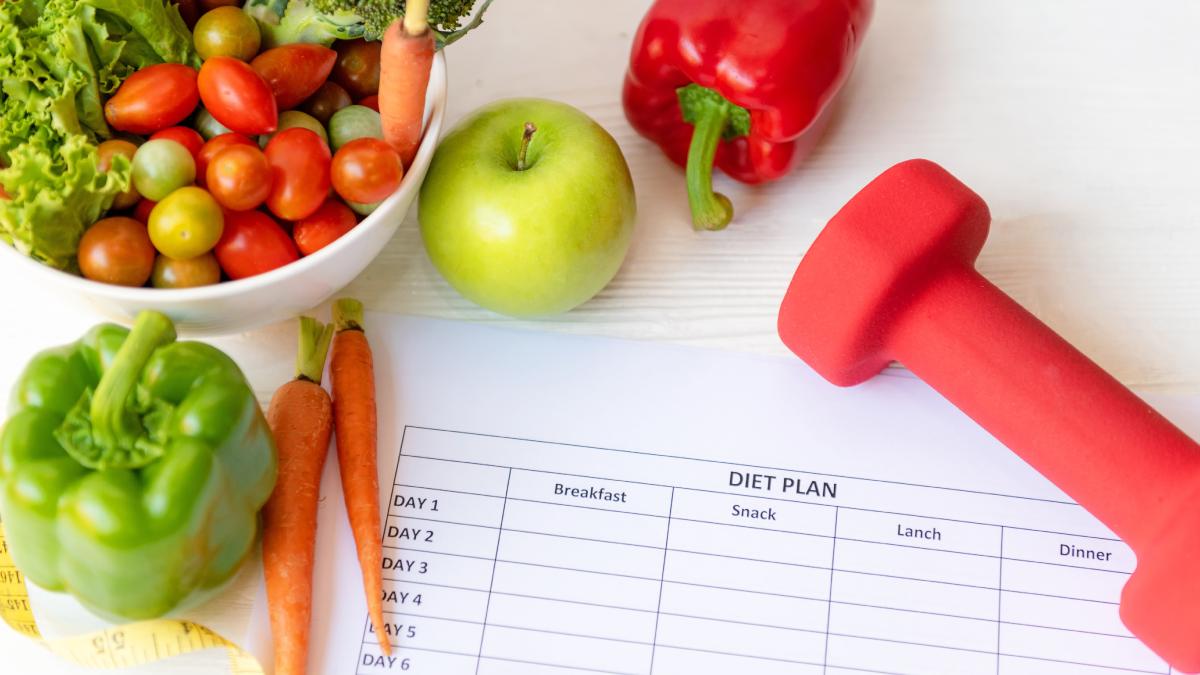Bureau d'un diététicien  avec un planning, des légumes et un haltère.