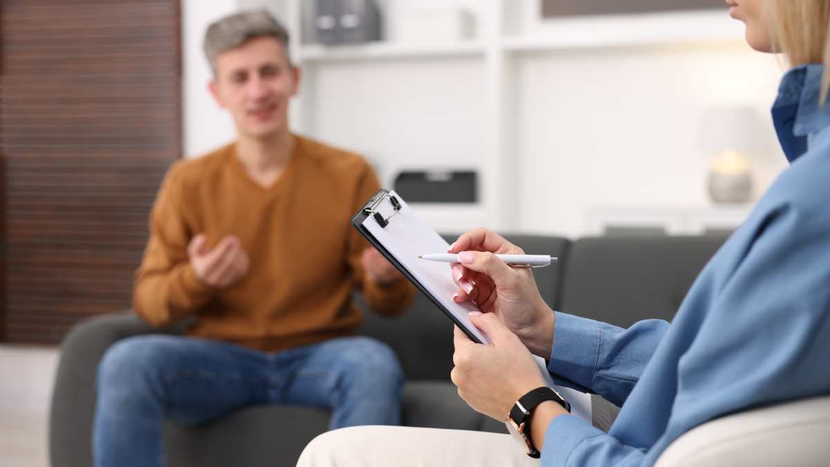 Une psychiatre qui reçoit un patient masculin dans son cabinet.