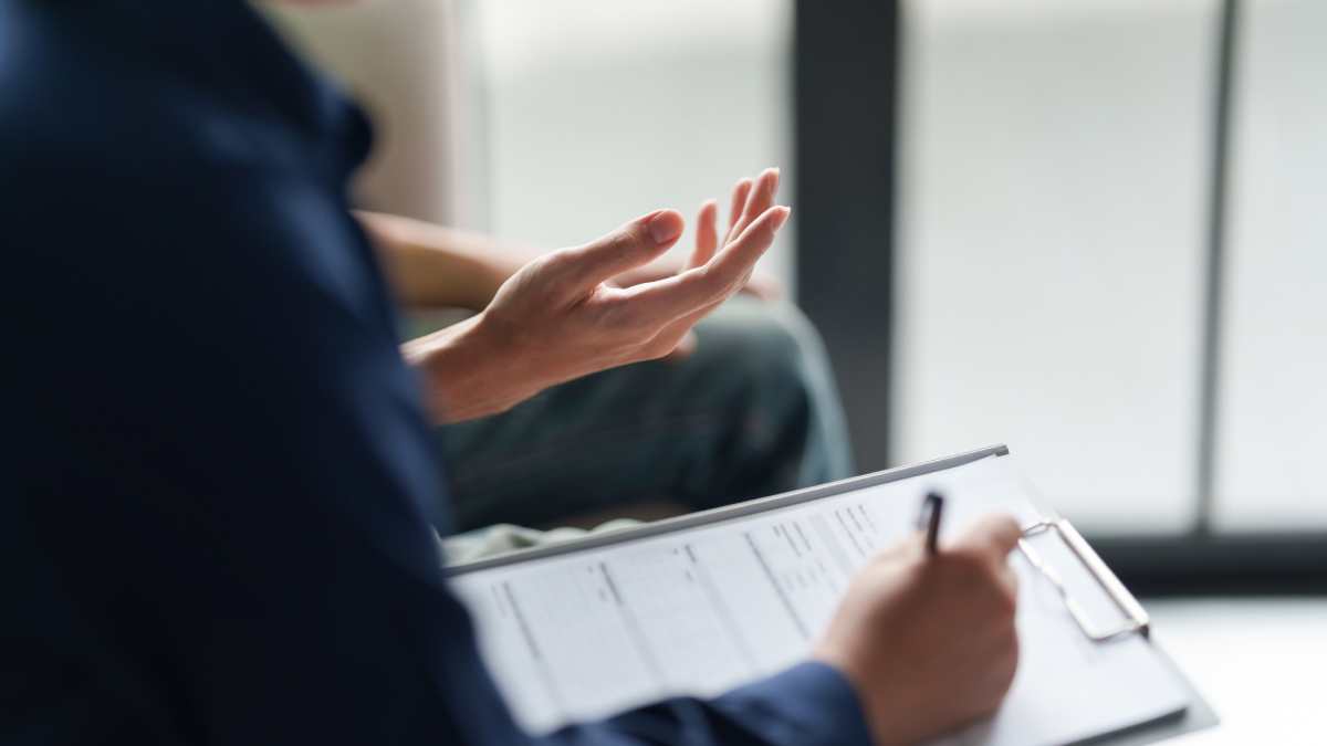 Psychiatre qui prend note pendant une consultation avec un patient.