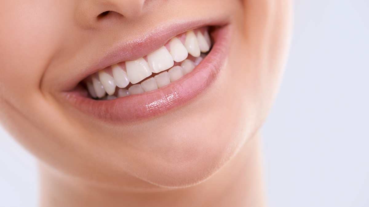Jeune femme qui sourit avec des dents blanches.