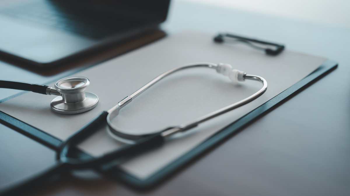 Stéthoscope posé sur un bureau avec un carnet de feuilles.